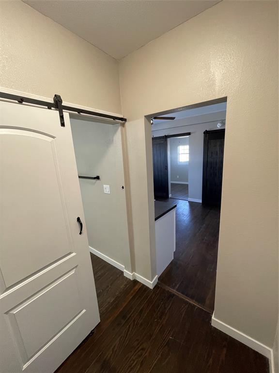 707 Northwest 4th Avenue, Unit 303 Mineral Wells, TX 76067 - Photo 5 of 9 a view of a hallway view with wooden floor and staircase