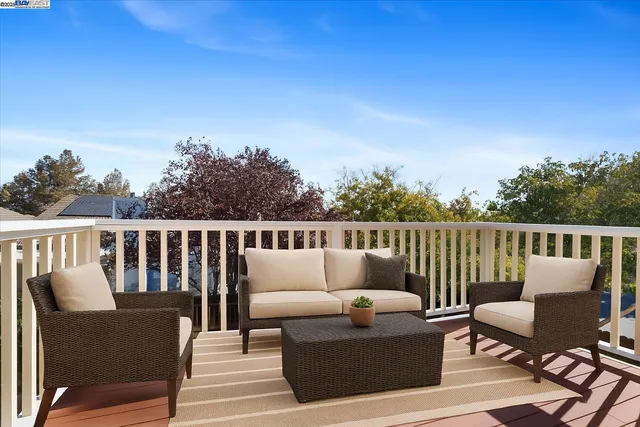 a balcony with wooden floor and outdoor seating