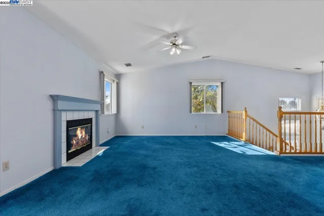 a view of an empty room with window and fireplace