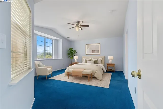 a spacious bedroom with a bed lamp and a potted plant