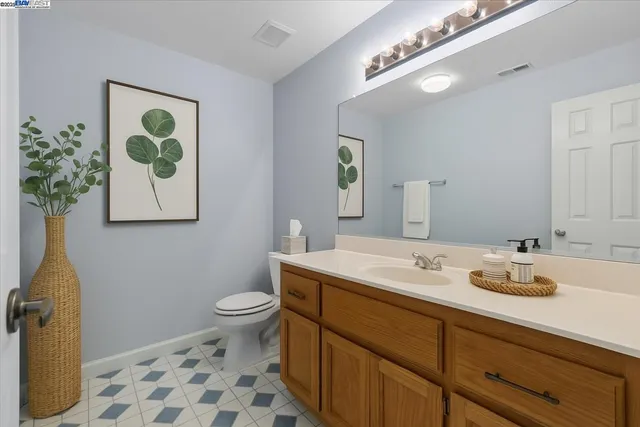 a bathroom with a sink mirror vanity and toilet