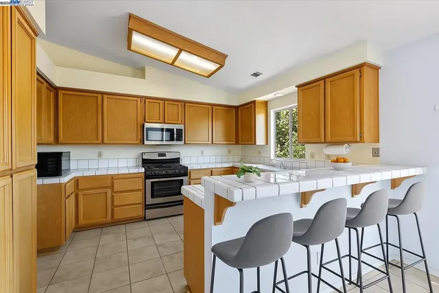 a kitchen with stainless steel appliances a stove a sink dishwasher and a refrigerator