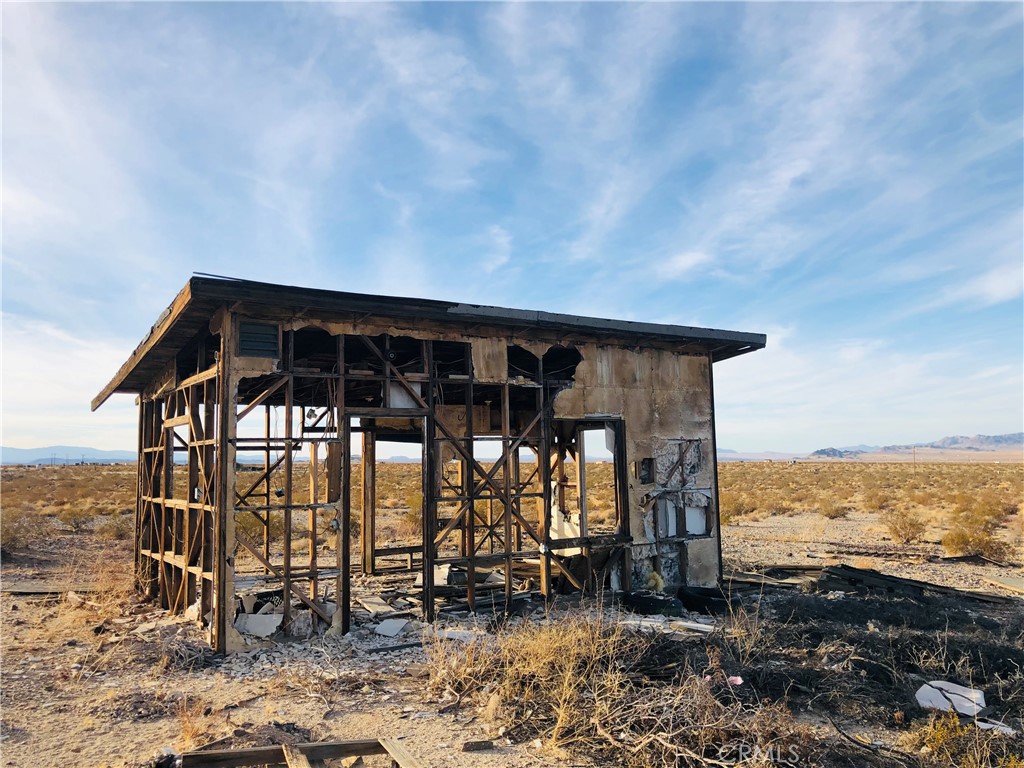 5 Pinto Mountain Road Twentynine Palms, CA 92277 - Photo 2 of 12 a backyard of a house with wooden floor table and chairs
