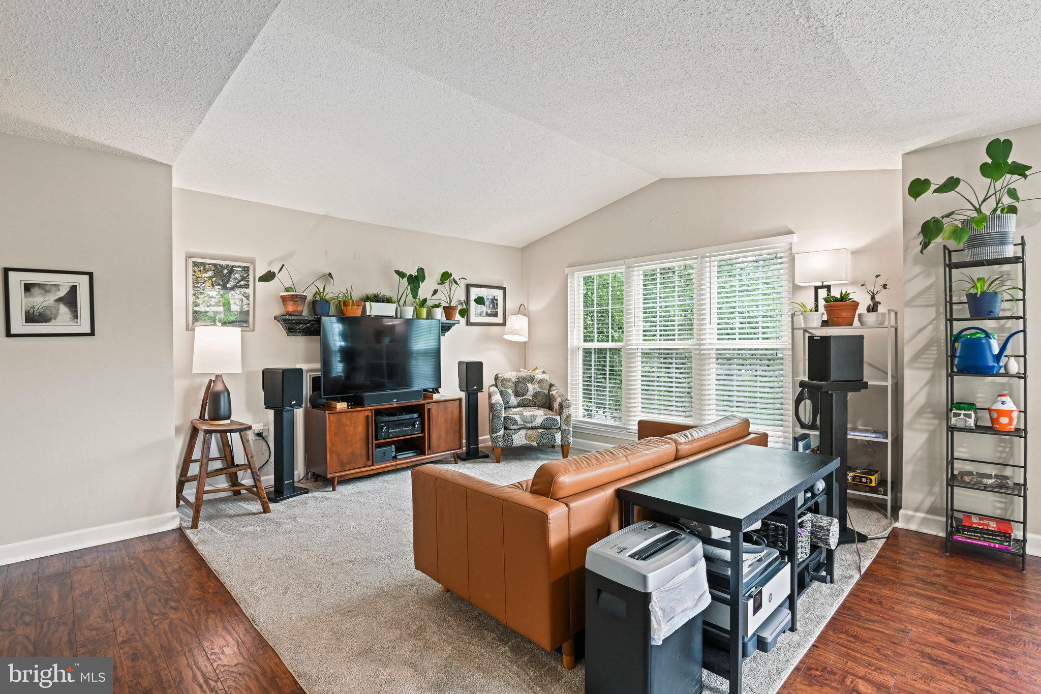 21013 Timber Ridge Terrace, Unit 202 Ashburn, VA 20147 - Photo 12 of 42 a living room with furniture a flat screen tv and a book shelf