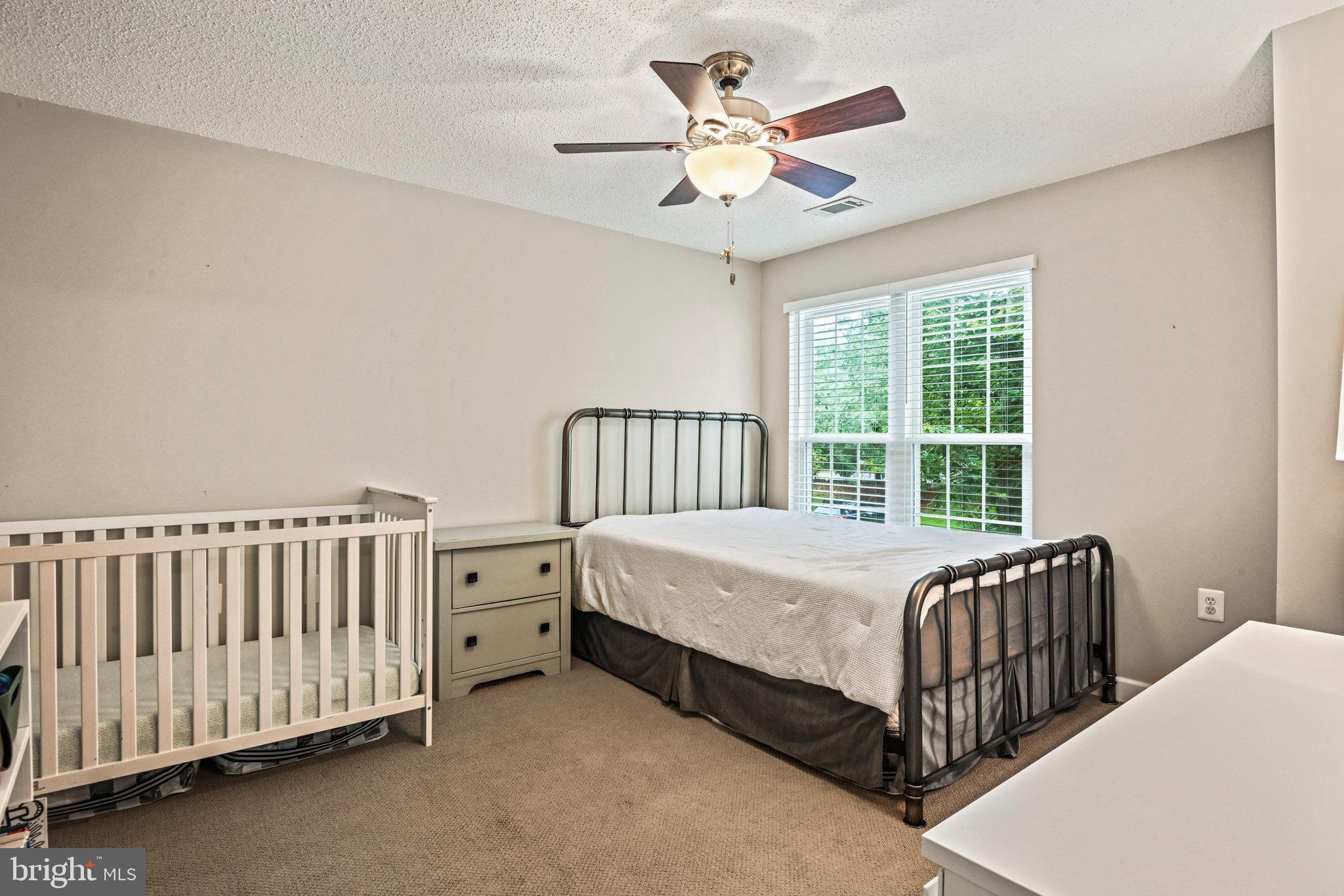 21013 Timber Ridge Terrace, Unit 202 Ashburn, VA 20147 - Photo 20 of 42 a bedroom with a bed and a chandelier