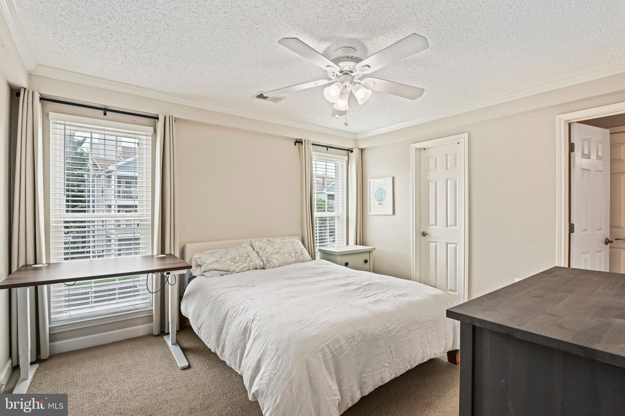 21013 Timber Ridge Terrace, Unit 202 Ashburn, VA 20147 - Photo 23 of 42 a bedroom with a large bed and a chandelier