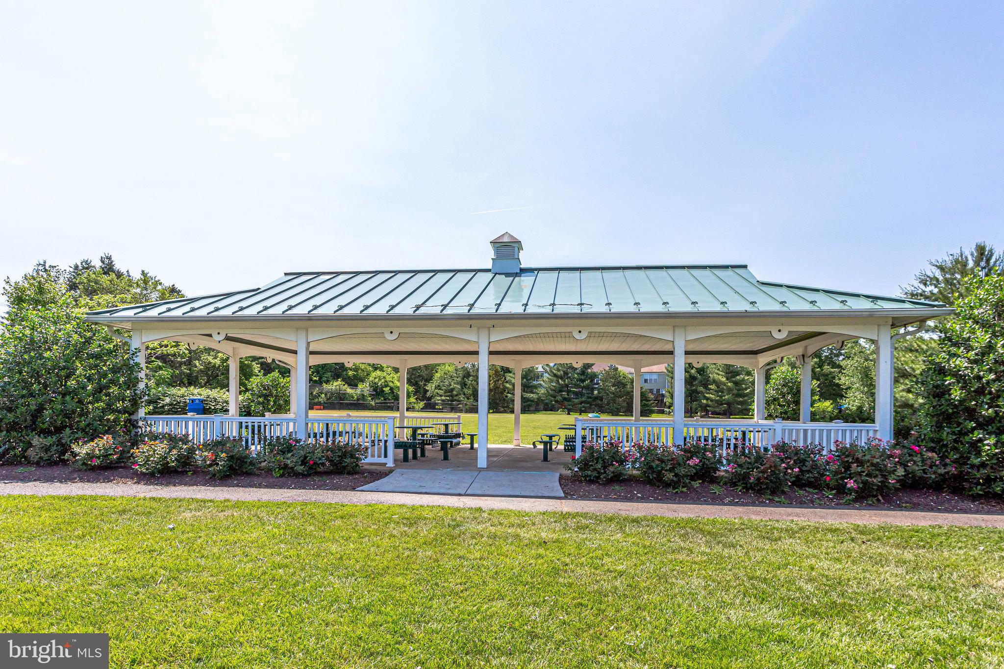 21013 Timber Ridge Terrace, Unit 202 Ashburn, VA 20147 - Photo 34 of 42 a view of a patio with table and chairs under an umbrella