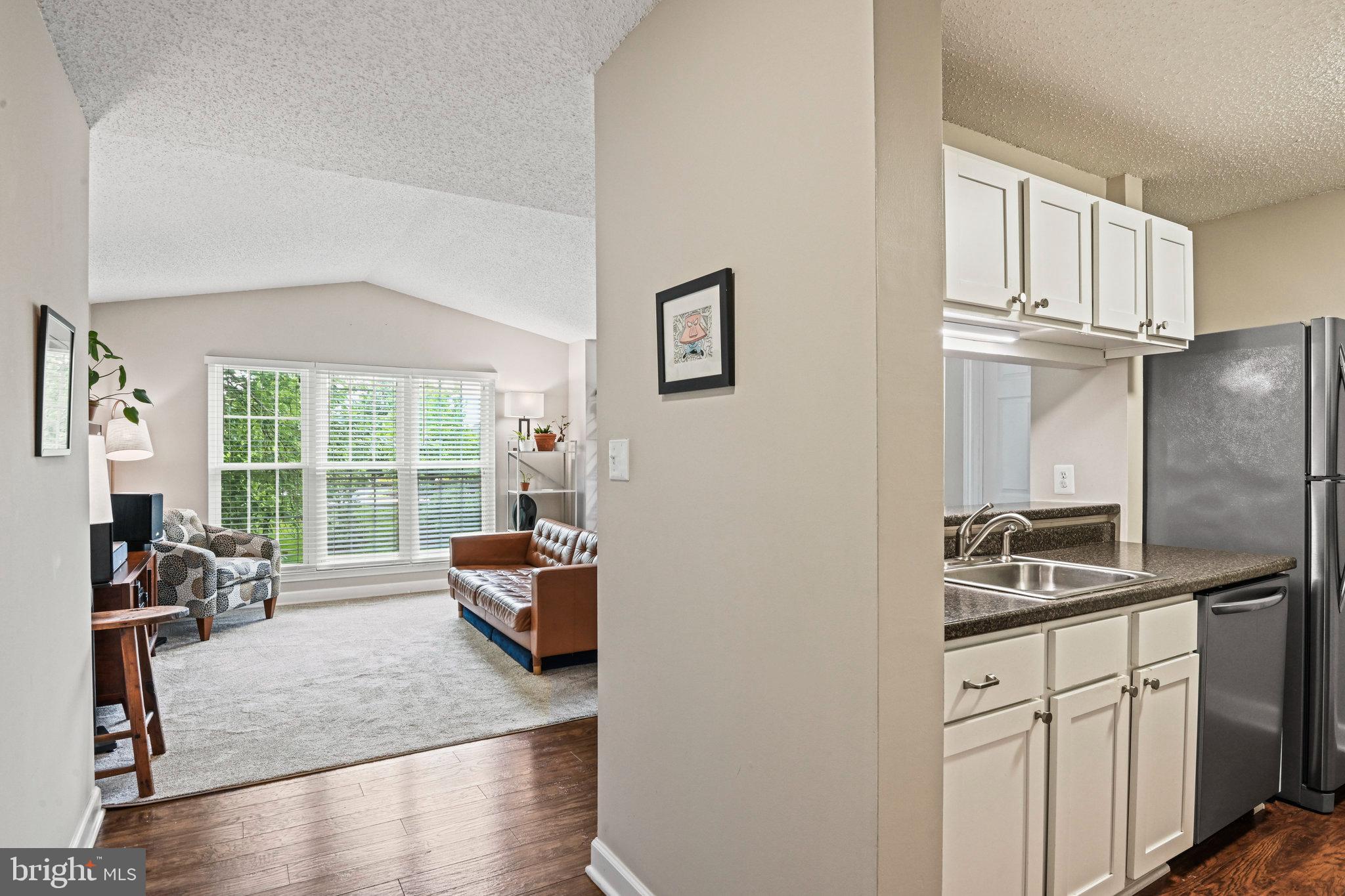 21013 Timber Ridge Terrace, Unit 202 Ashburn, VA 20147 - Photo 4 of 42 a kitchen with stainless steel appliances granite countertop a sink refrigerator and window
