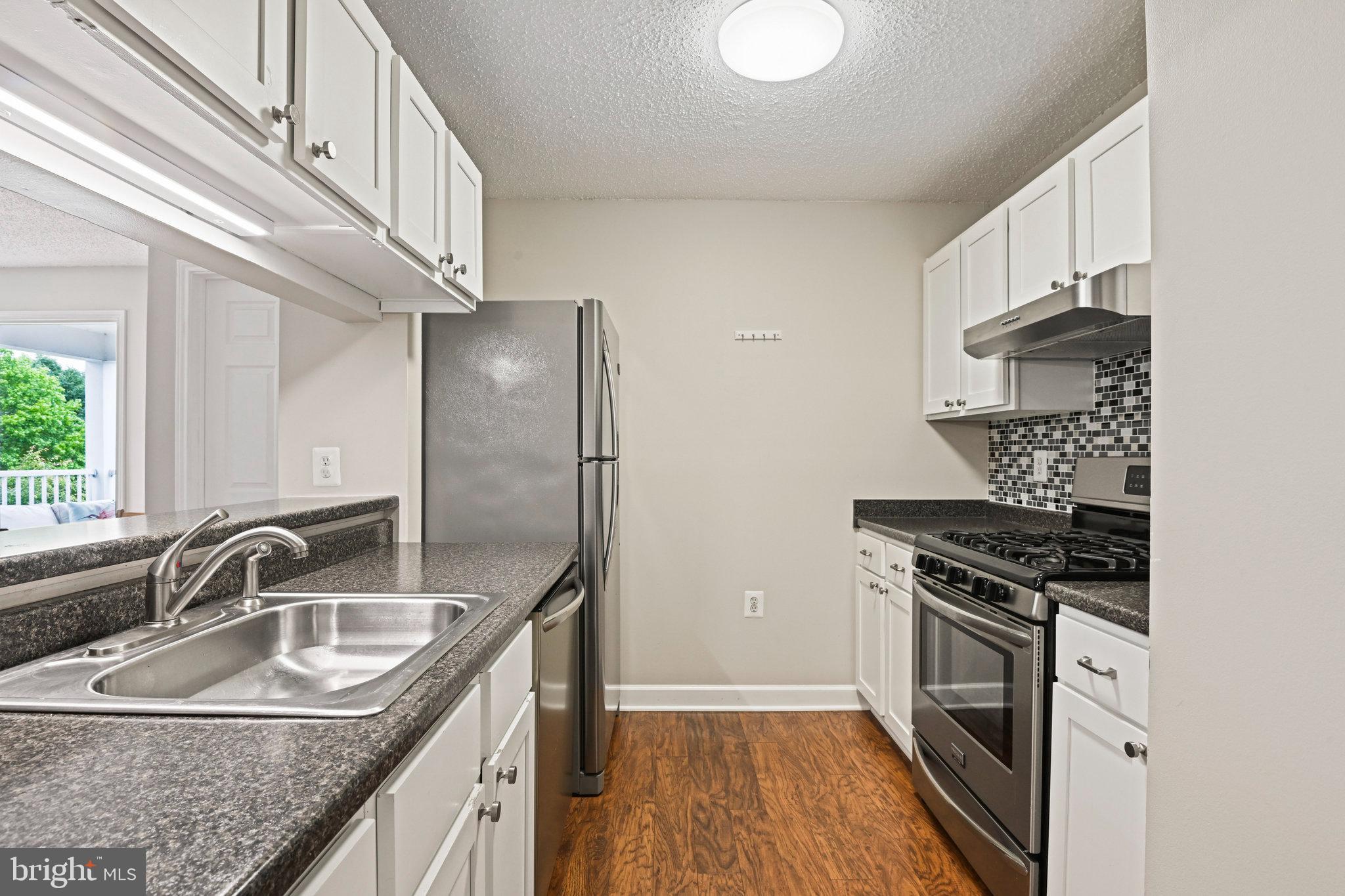 21013 Timber Ridge Terrace, Unit 202 Ashburn, VA 20147 - Photo 5 of 42 a kitchen with granite countertop a sink stainless steel appliances and cabinets