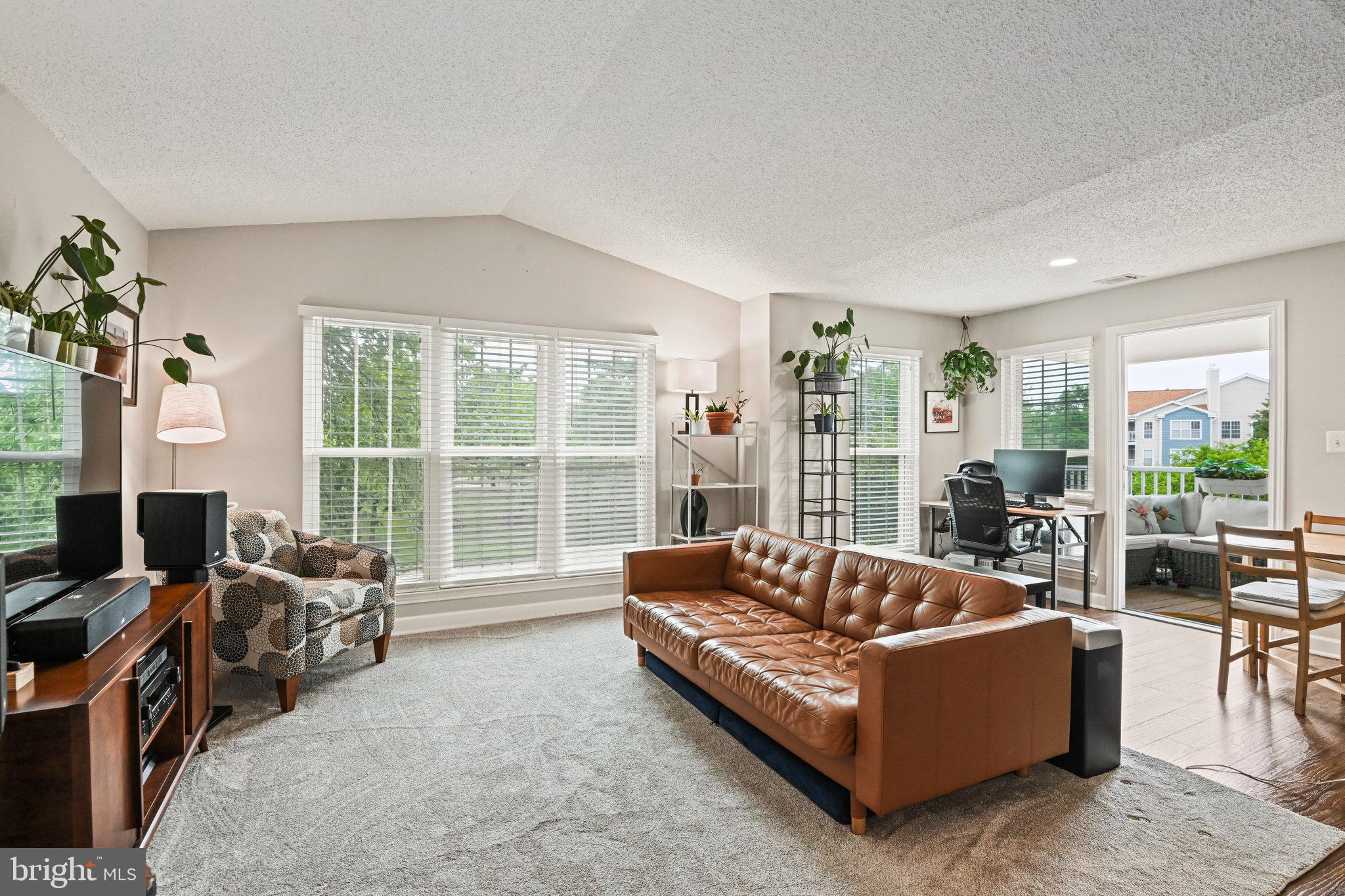 21013 Timber Ridge Terrace, Unit 202 Ashburn, VA 20147 - Photo 9 of 42 a living room with furniture and a large window