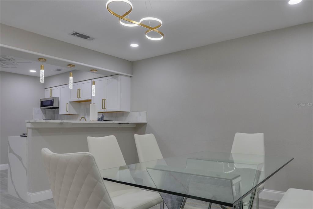 110 Duval Road Winter Haven, FL 33884 - Photo 15 of 25 a kitchen with a dining table chairs sink and cabinets