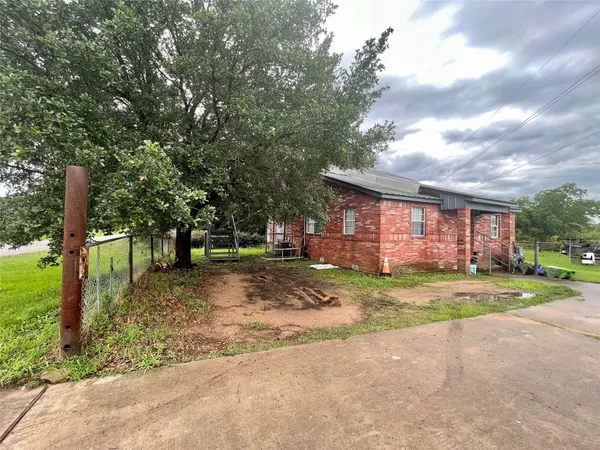 a view of a house with a yard and large trees