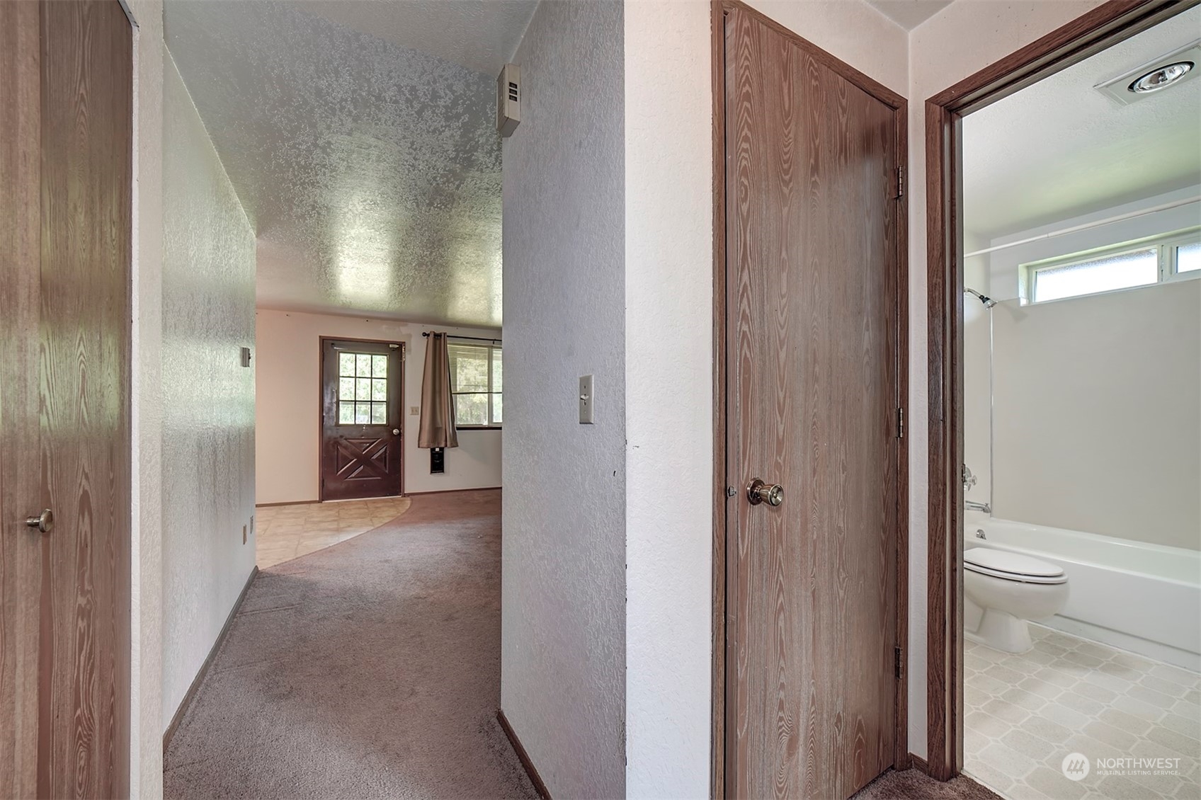 7615 Illahee Road Northeast Bremerton, WA 98311 - Photo 12 of 23 a view of a hallway with wooden floor and a bathroom