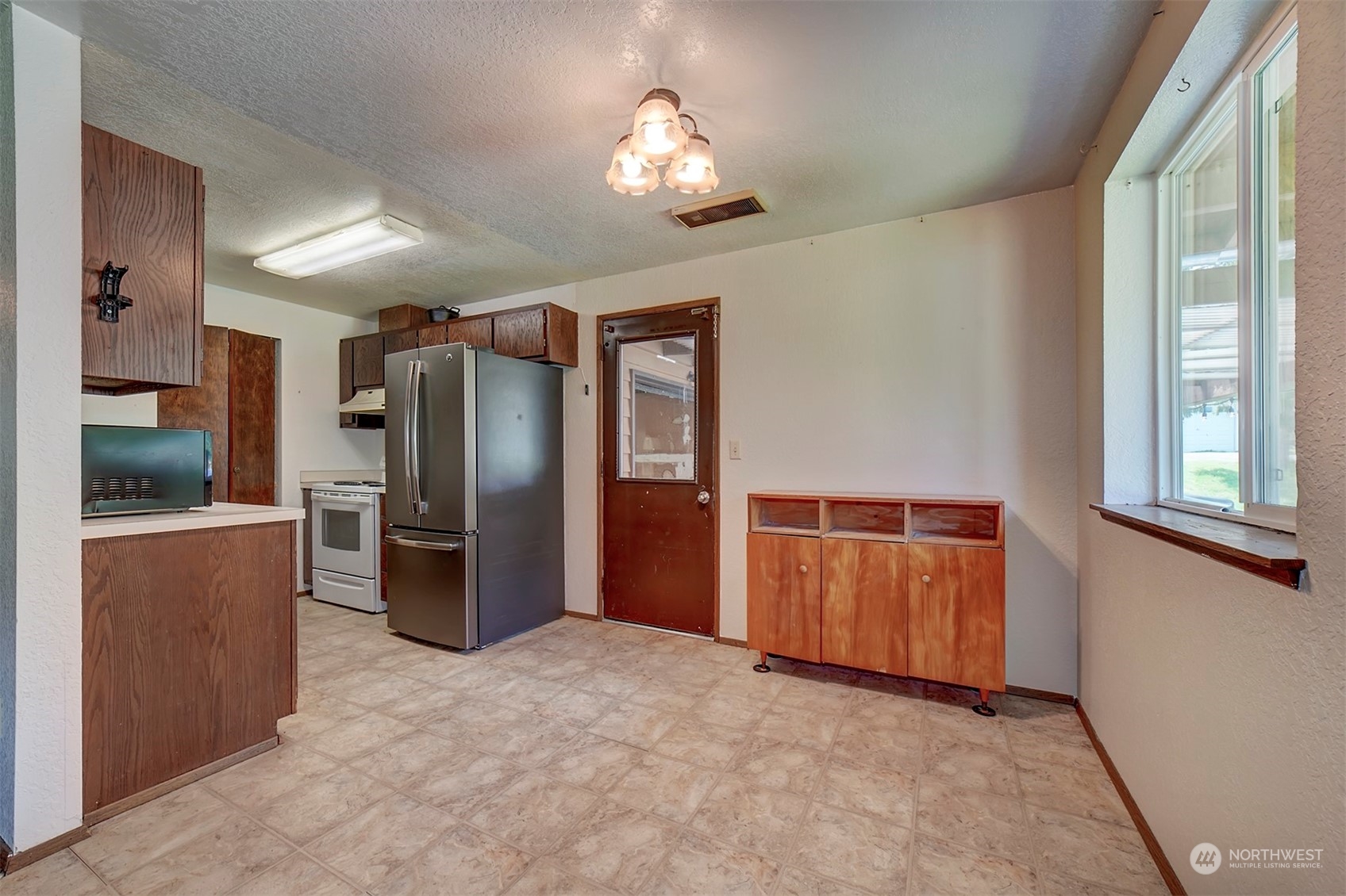 7615 Illahee Road Northeast Bremerton, WA 98311 - Photo 6 of 23 a kitchen with refrigerator and window