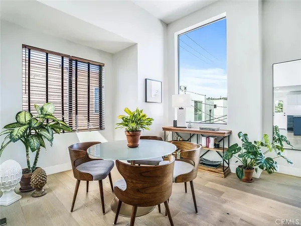 a dining room with furniture and potted plants