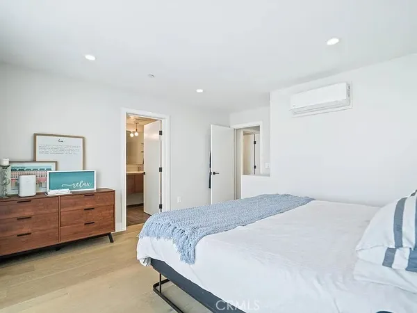 a spacious bedroom with a bed and a night stand