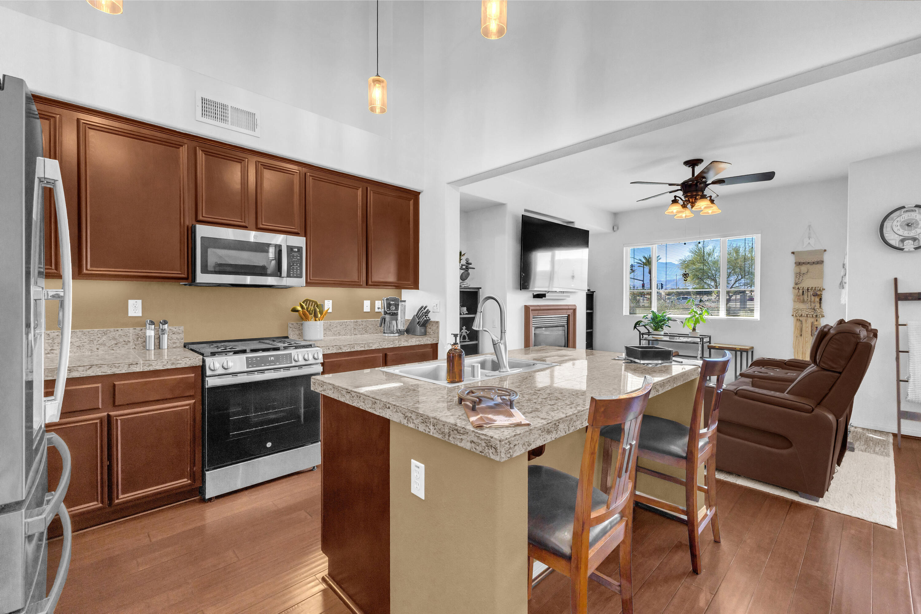73268 Azure Rain, Unit 102 Palm Desert, CA 92211 - Photo 11 of 44 a kitchen with stainless steel appliances granite countertop a stove top oven a sink dishwasher a dining table and chairs with wooden floor