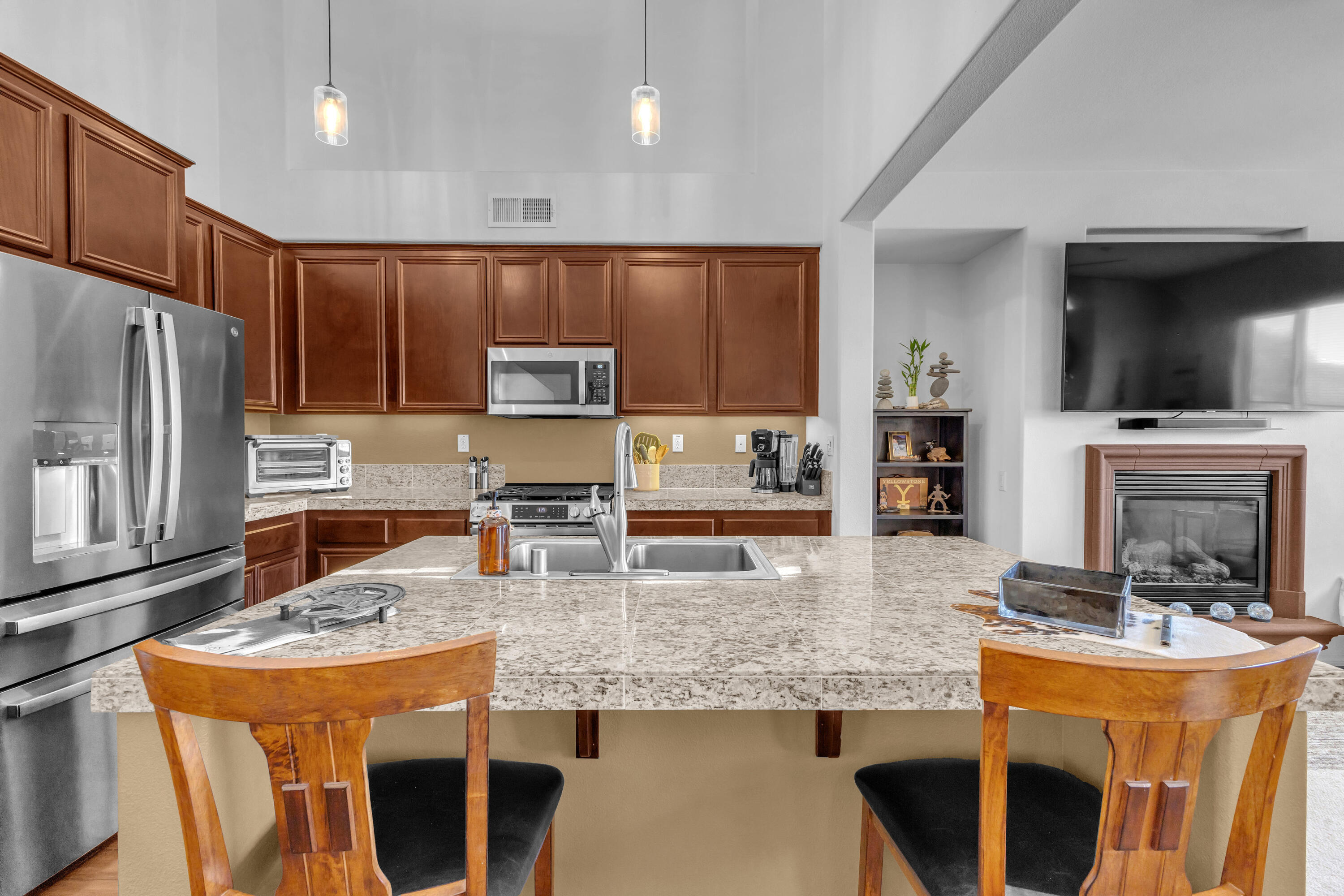 73268 Azure Rain, Unit 102 Palm Desert, CA 92211 - Photo 12 of 44 a kitchen with kitchen island granite countertop a stove a sink a microwave a refrigerator and chairs