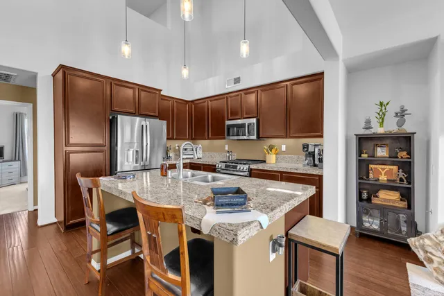 a kitchen with stainless steel appliances granite countertop a stove refrigerator sink and cabinets