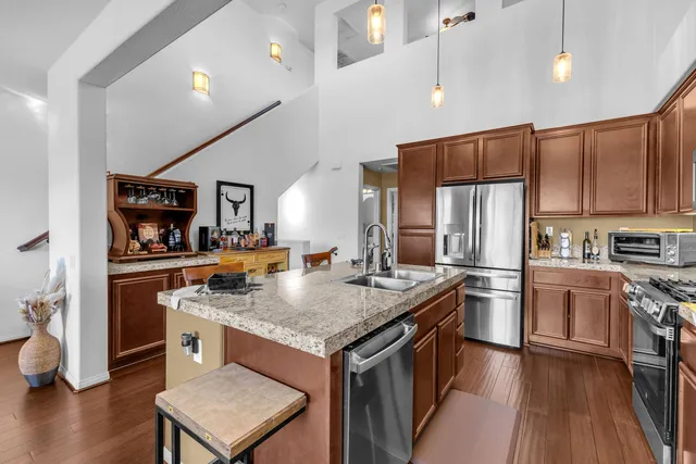 a kitchen with stainless steel appliances granite countertop a refrigerator and a sink