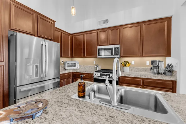 a kitchen with stainless steel appliances a stove a sink and a refrigerator