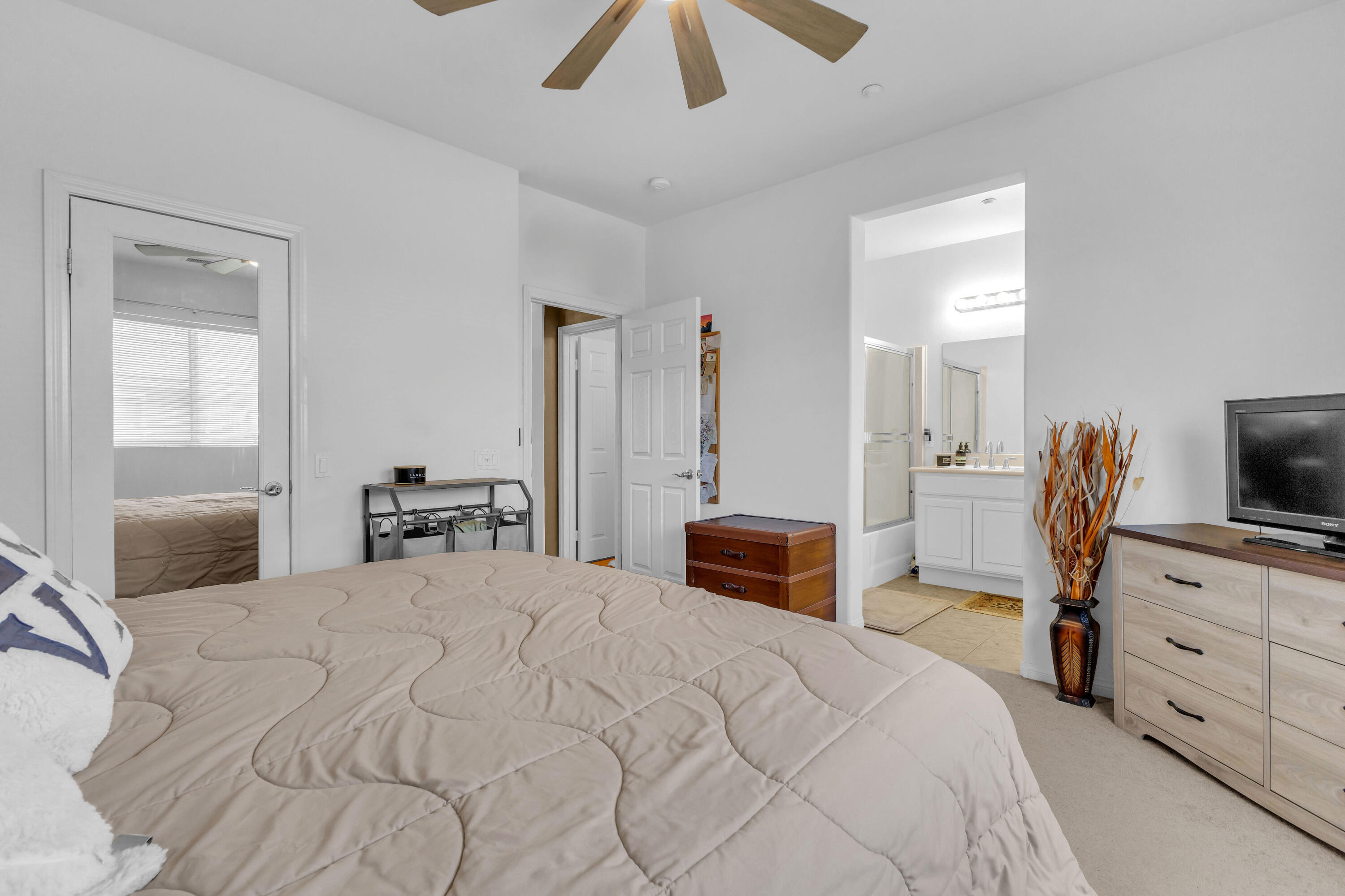 73268 Azure Rain, Unit 102 Palm Desert, CA 92211 - Photo 29 of 44 a bedroom with a bed and a flat tv screen on dresser