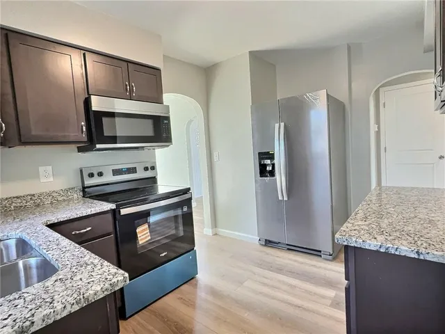 a kitchen with granite countertop wooden cabinets and stainless steel appliances