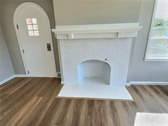 a view of empty room with window and wooden floor