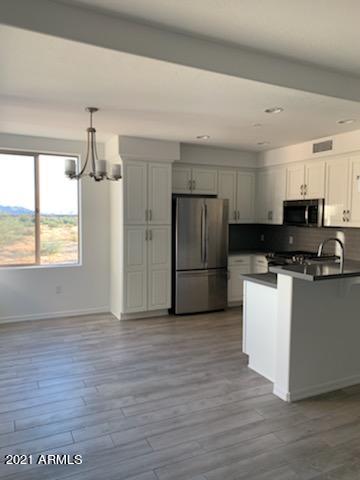 17850 North 68th Street, Unit 2063 Phoenix, AZ 85054 - Photo 12 of 23 a kitchen with a refrigerator and a stove top oven