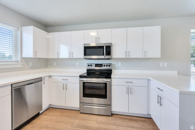 572 South 100 West, Unit E210 Springville, UT 84663 - Photo 15 of 35 Modern kitchen featuring white shaker-style cabinetry and light-toned countertops