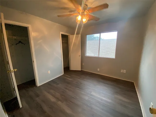 a view of a house with a wooden fence and a big yard