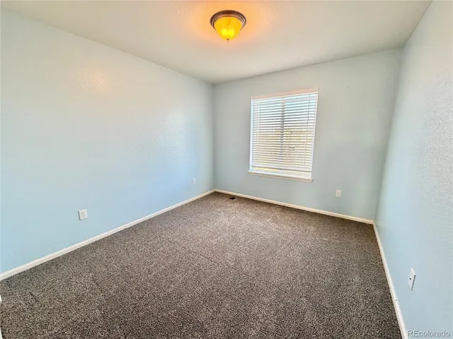 a view of a hallway with staircase and white walls