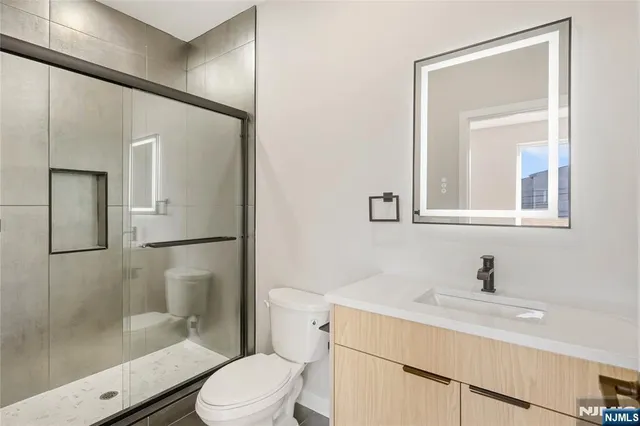 a bathroom with a sink toilet a mirror and shower