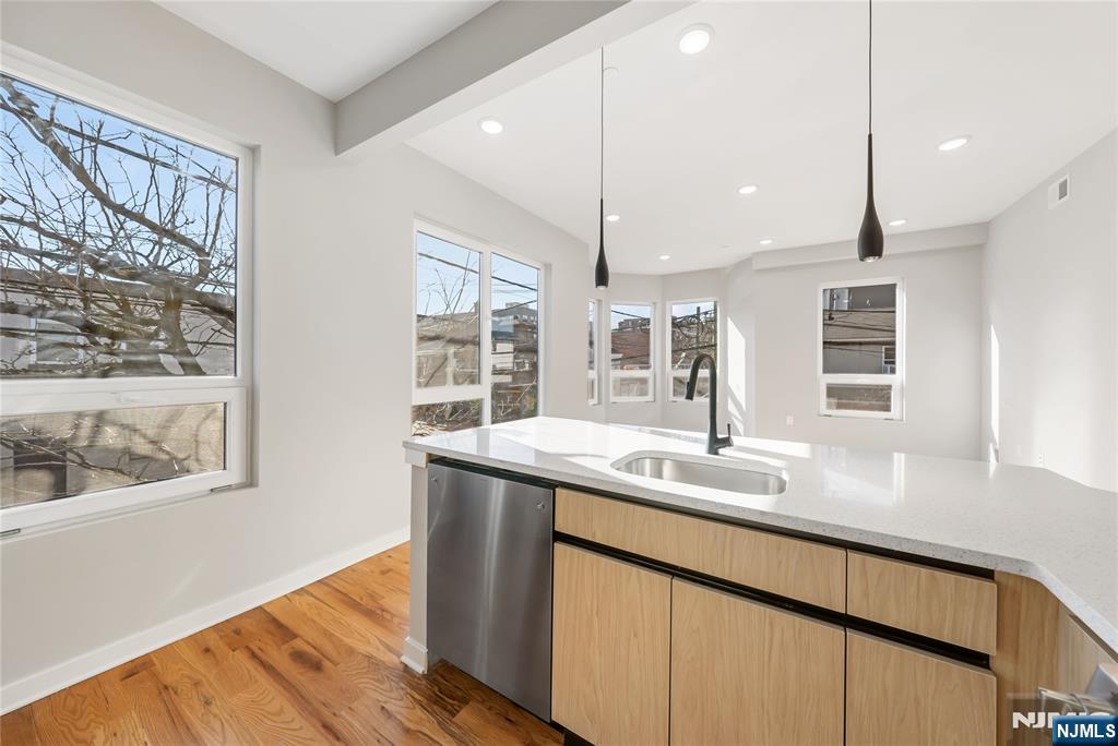108 Fleming Avenue, Unit 2B Newark, NJ 07105 - Photo 4 of 21 a kitchen with stainless steel appliances granite countertop a sink a window and wooden floor