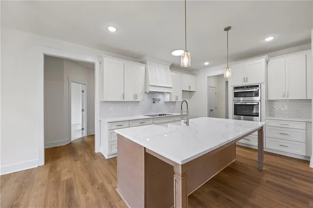 a kitchen with a refrigerator a sink and wooden floor