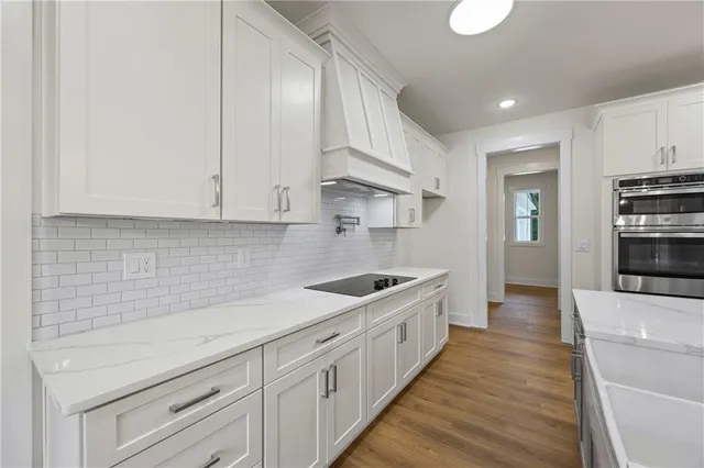 a kitchen with granite countertop a sink and stainless steel appliances
