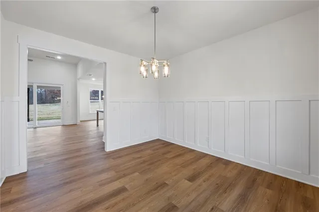 a view of a room with wooden floor and a chandelier