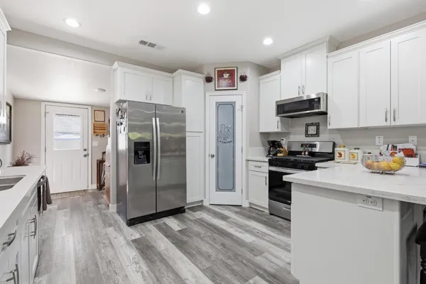 a kitchen with stainless steel appliances a refrigerator and a stove top oven