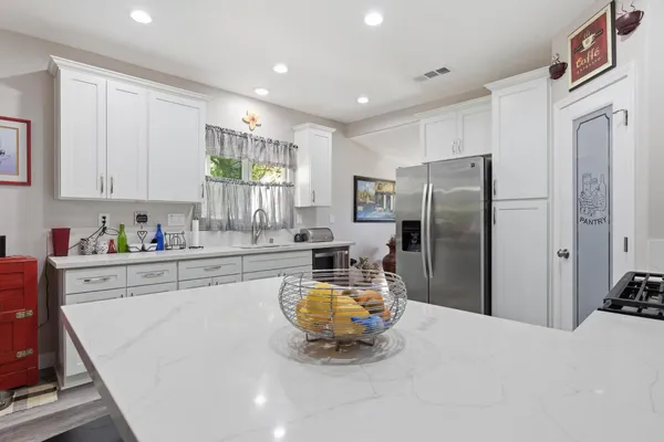 a kitchen with stainless steel appliances a refrigerator sink and cabinets