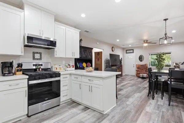a kitchen with stainless steel appliances granite countertop a stove and a wooden floors