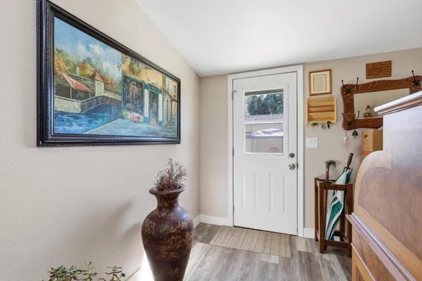 a picture of a room with wooden floor and a large window