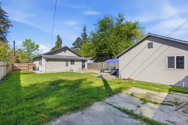 a backyard of a house with table and chairs