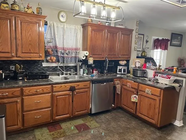 a kitchen with stainless steel appliances granite countertop a sink a stove cabinets and a dining table