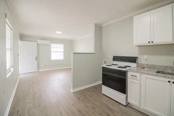 a kitchen with a stove and white cabinets