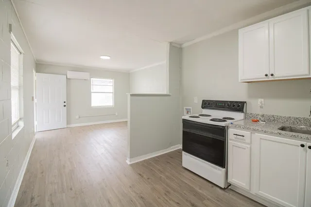 a kitchen with a stove and white cabinets