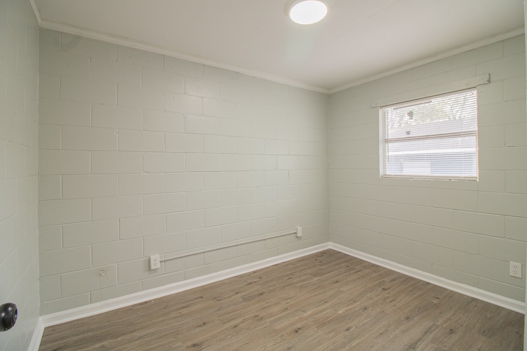 2408 16th Avenue, Unit A Columbus, GA 31901 - Photo 6 of 8 wooden floor in an empty room with a window