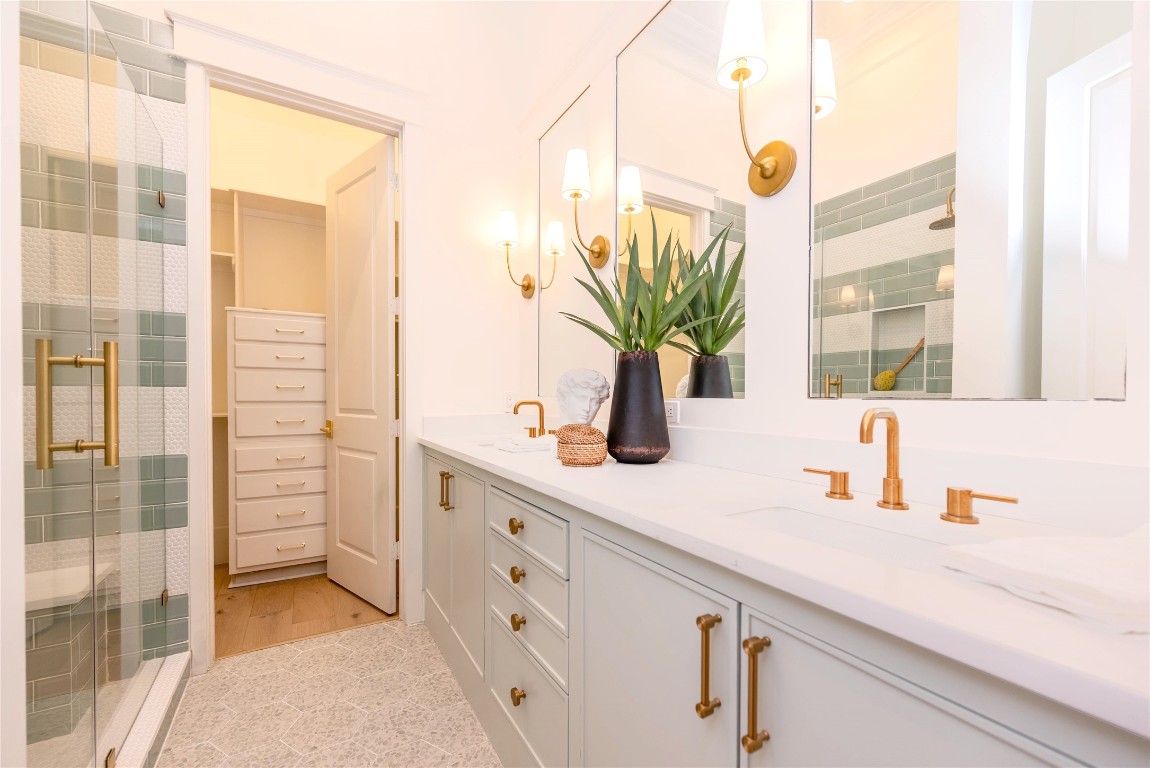 11610 Beachside Galveston, TX 77554 - Photo 26 of 50 This en-suite bathroom showcases double sinks, a large walk-in shower, and elegant bronze finishes throughout.
