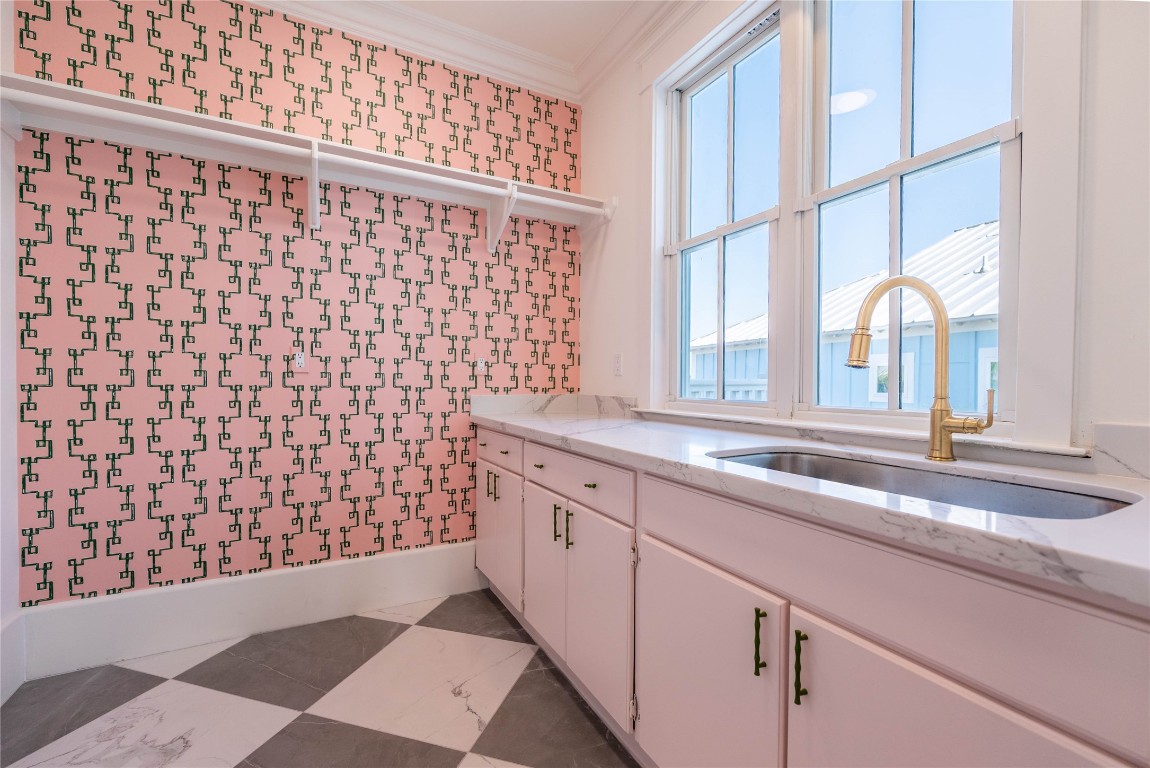 11610 Beachside Galveston, TX 77554 - Photo 28 of 50 Conveniently located on the second floor, the utility room offers ample space for cleaning, gorgeous wallpaper, and accommodates an oversized washer and dryer. Notice how the floor tiles from the mudroom accent this space as well.