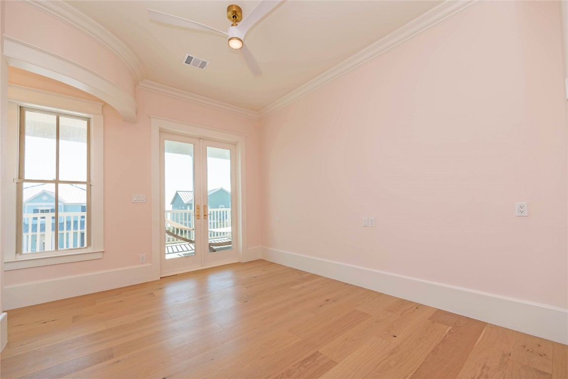 11610 Beachside Galveston, TX 77554 - Photo 29 of 50 an empty room with wooden floor and windows