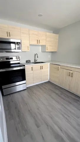 a kitchen with wooden floors and appliances